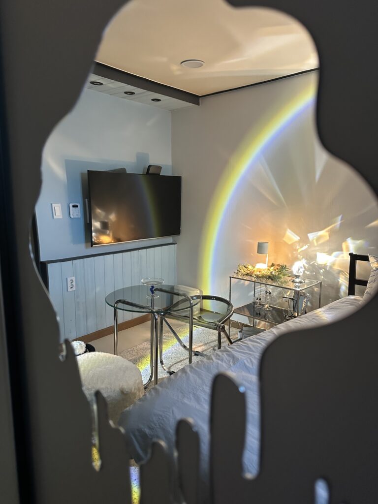 Mirror reflection showing pastel blue ballet core bedroom with rainbow light effects perfect for Instagram photos
