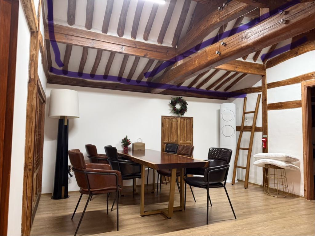 Traditional Korean hanok living room with exposed wooden ceiling beams showing indirect lighting placement marked with purple highlight lines for Airbnb renovation